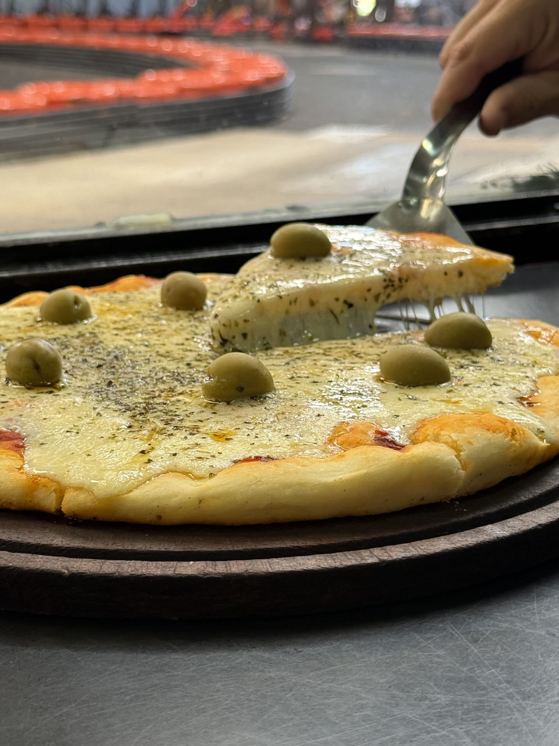 Pizza en Podio Bar con la pista de karts de fondo